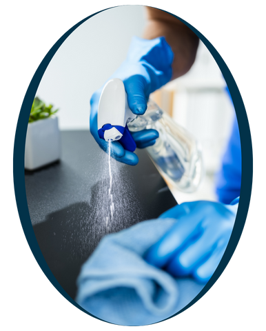 A oval shape frame and a man in blue overalls is diligently cleaning a countertop with a cloth in a well-lit kitchen setting.