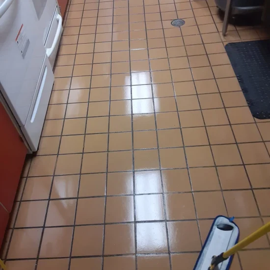 A clean kitchen featuring a mop and a vacuum cleaner positioned near the cabinets.