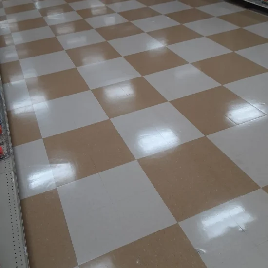 A store interior featuring a checkered floor and neatly arranged shelves filled with various products.