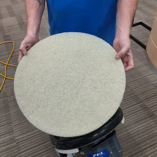 A man holds a large round disc in his hand, showcasing its size and shape.