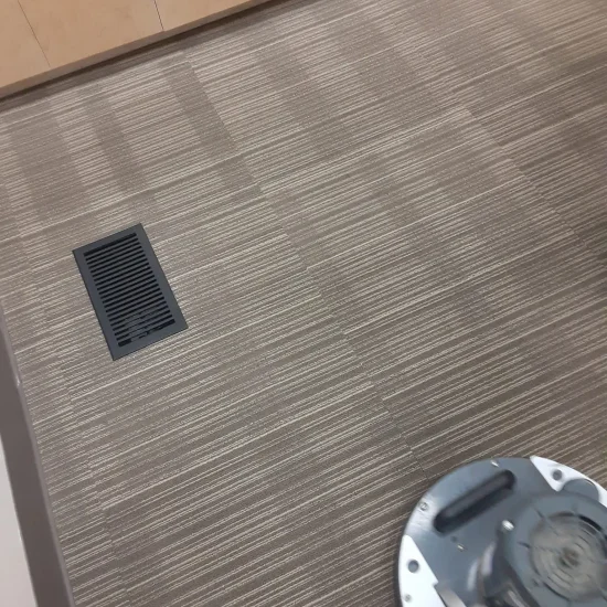 A vacuum cleaner placed on the floor in a tidy room, ready for use.